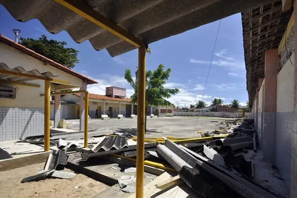 Pátio de escola com telhas quebradas no chão