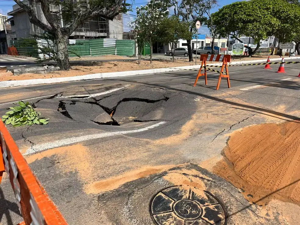 Asfalto afundando e rachado, isolado com cavaletes